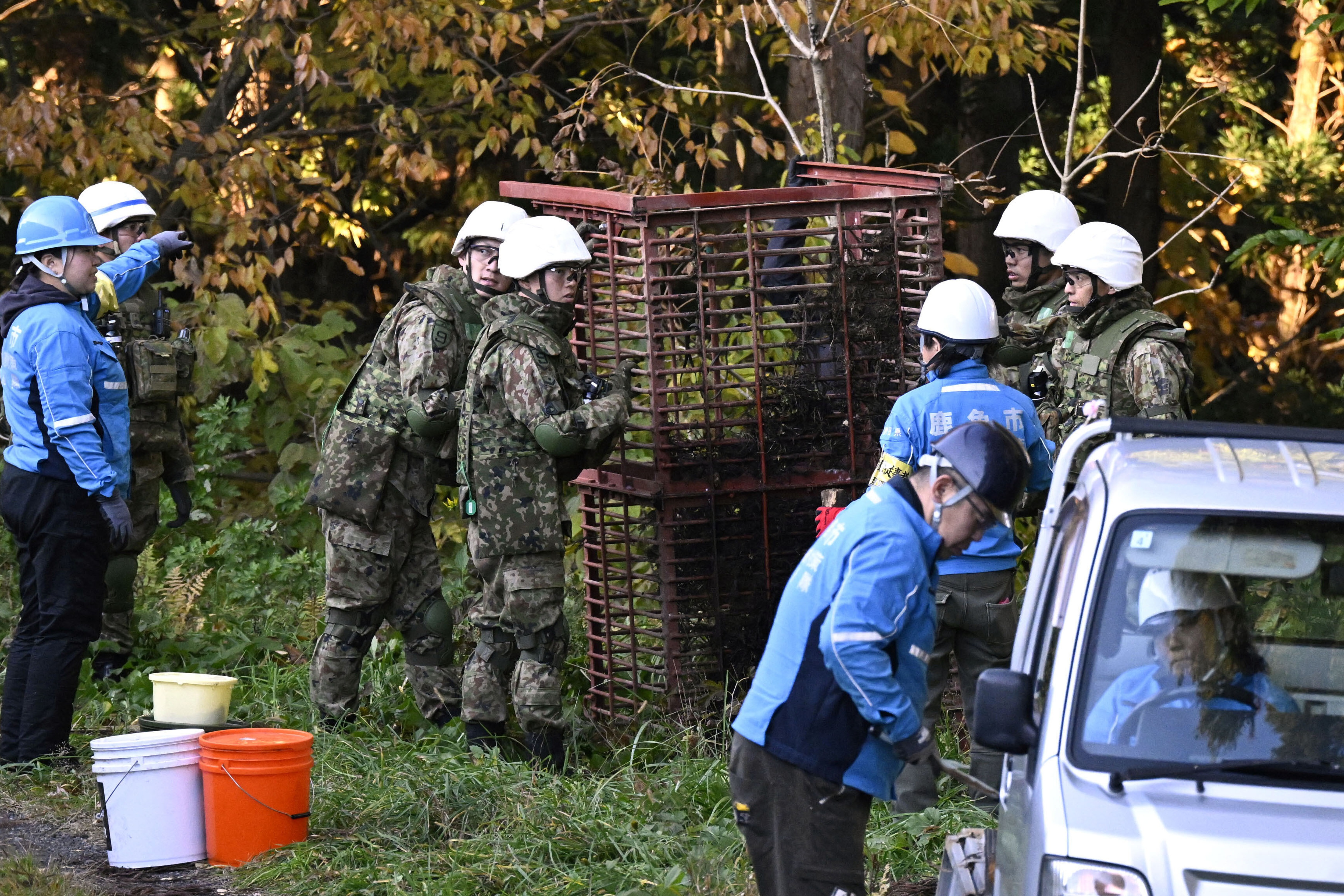 Japan Ground Self-Defense Force members and others set up a box trap to capture bears in Kazuno, Akita prefecture, northern Japan on Wednesday.